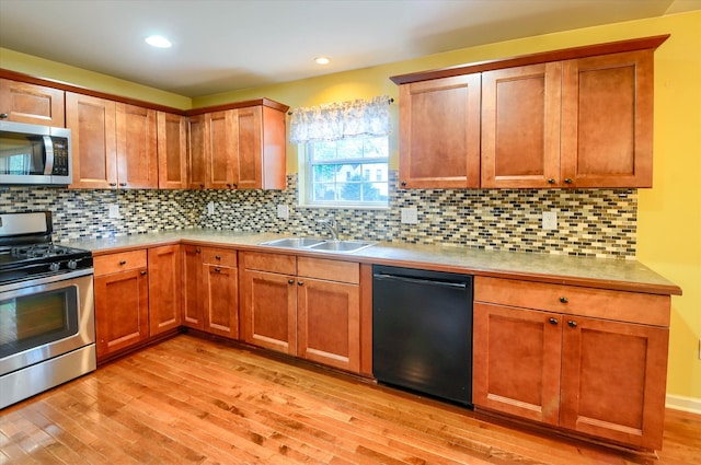 kitchen featuring backsplash, light hardwood / wood-style floors, sink, and stainless steel appliances