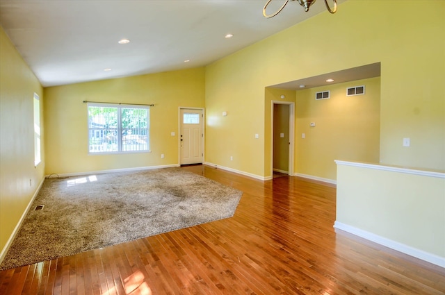 interior space with wood-type flooring, lofted ceiling, and a notable chandelier