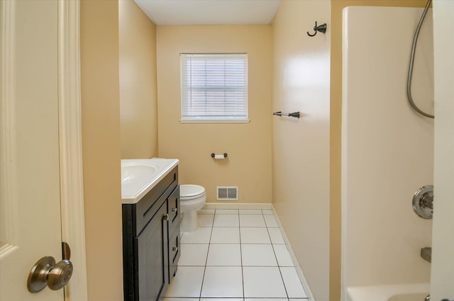 bathroom with toilet, vanity, and tile patterned floors