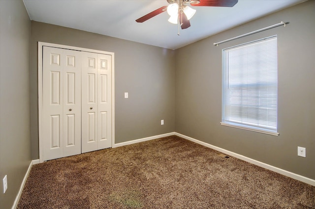 unfurnished bedroom featuring carpet floors, a closet, multiple windows, and ceiling fan