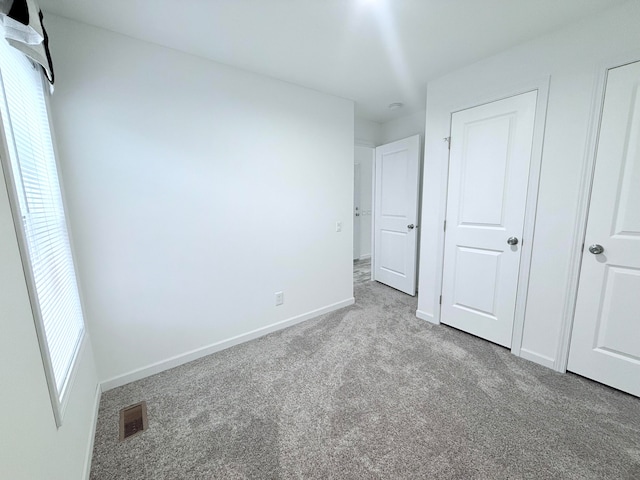 unfurnished bedroom featuring light carpet