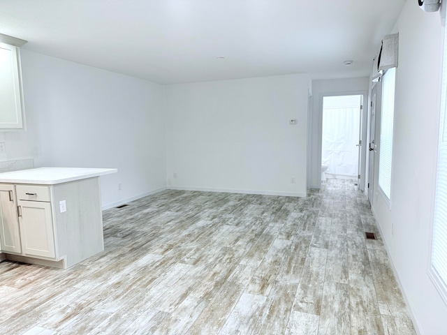 unfurnished living room featuring a wealth of natural light and light wood-type flooring