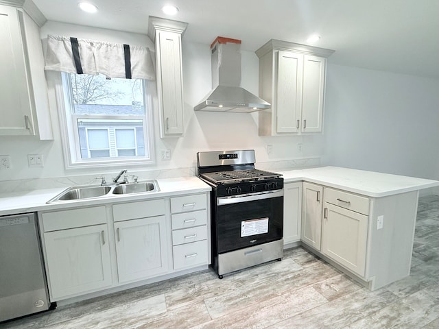 kitchen featuring white cabinetry, sink, wall chimney exhaust hood, stainless steel appliances, and kitchen peninsula