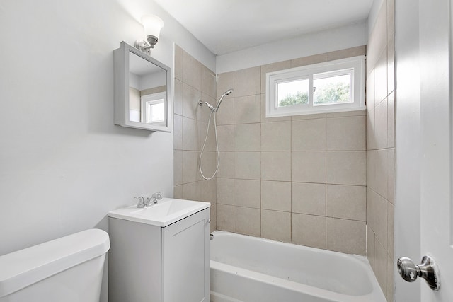 full bathroom with vanity, tiled shower / bath combo, and toilet