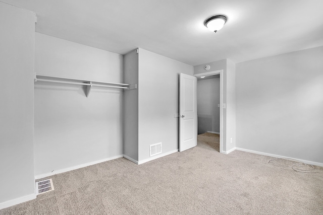 unfurnished bedroom with light carpet and a closet