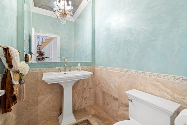 half bathroom featuring a chandelier, toilet, and tile walls