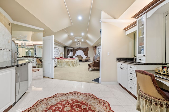 kitchen with dark stone countertops, lofted ceiling, white cabinets, glass insert cabinets, and light carpet