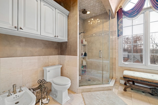 full bathroom with a wealth of natural light, toilet, a stall shower, and tile walls