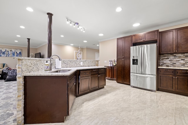 kitchen with a sink, light stone counters, tasteful backsplash, stainless steel fridge with ice dispenser, and crown molding