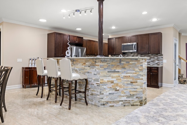 kitchen featuring stainless steel appliances, tasteful backsplash, dark brown cabinets, and ornamental molding