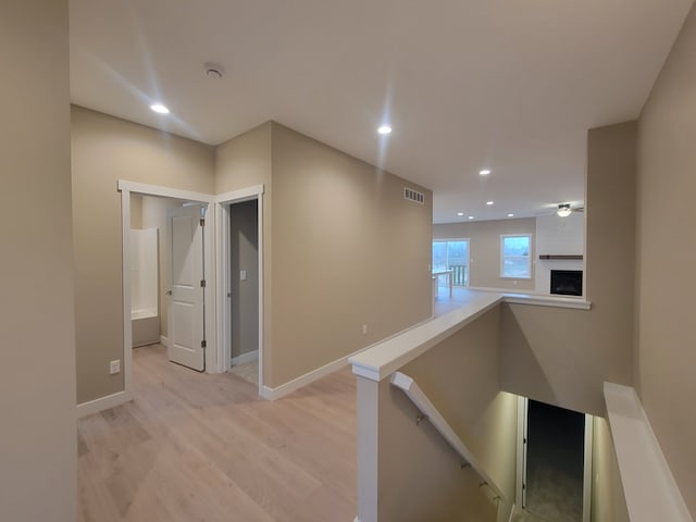 corridor with light hardwood / wood-style floors