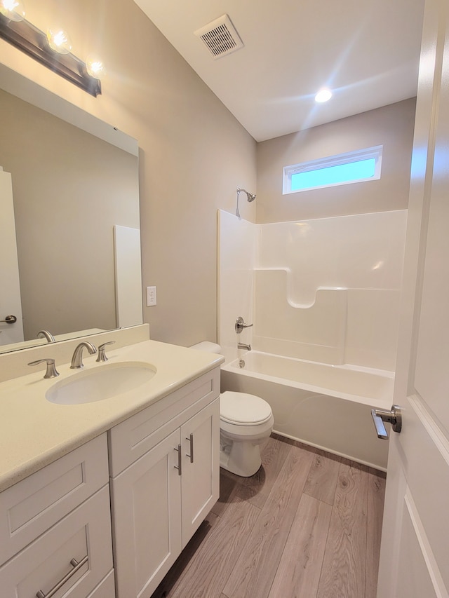 full bathroom featuring wood-type flooring, vanity, shower / bath combination, and toilet