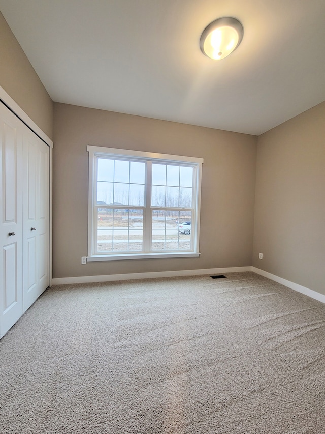 unfurnished bedroom featuring carpet and a closet