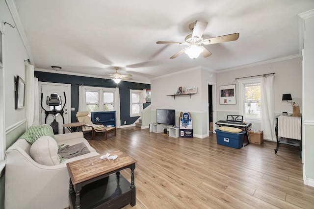 living room featuring ceiling fan, plenty of natural light, crown molding, and light wood-type flooring