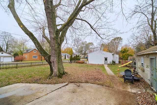 view of yard featuring a patio area, a garage, and an outdoor structure