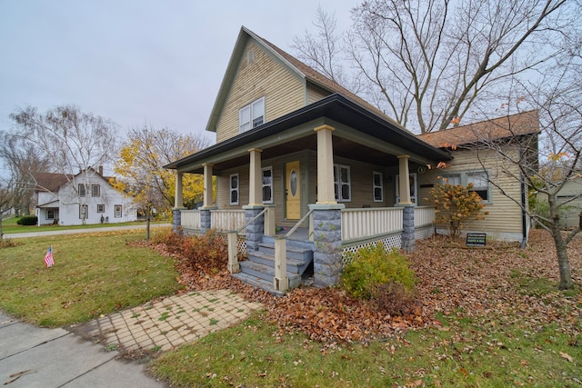 view of front of property featuring covered porch and a front yard