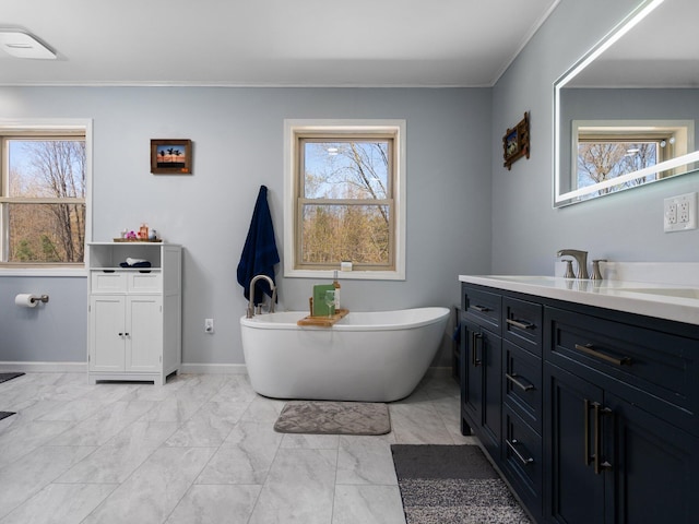 bathroom with vanity, crown molding, and a tub