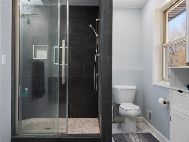 bathroom featuring toilet and a shower with door