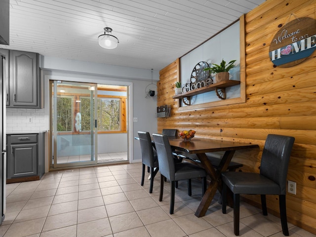 tiled dining space with wood ceiling and log walls