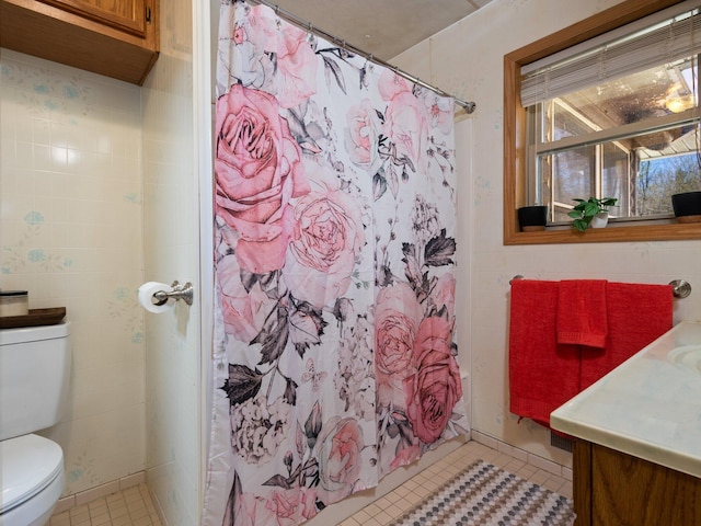 bathroom featuring tile patterned flooring, vanity, toilet, and tile walls