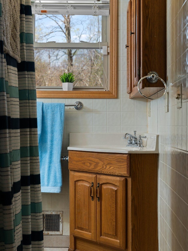 bathroom with vanity, tile walls, and backsplash