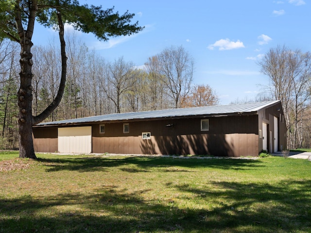 rear view of house featuring an outbuilding and a yard