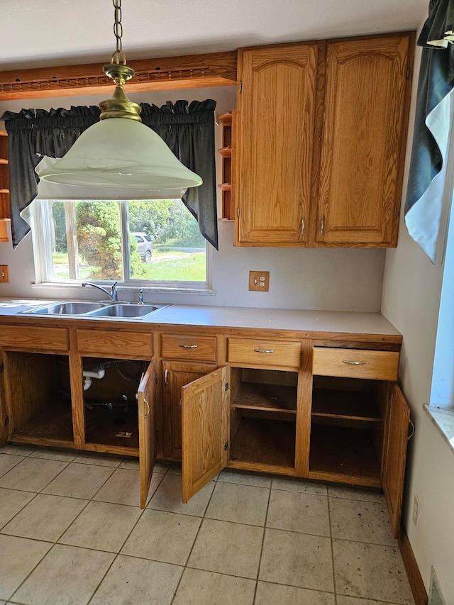 kitchen with light tile patterned floors, hanging light fixtures, and sink