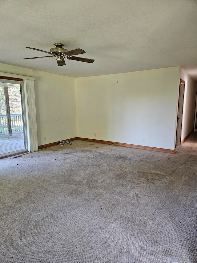 carpeted empty room featuring ceiling fan and a textured ceiling