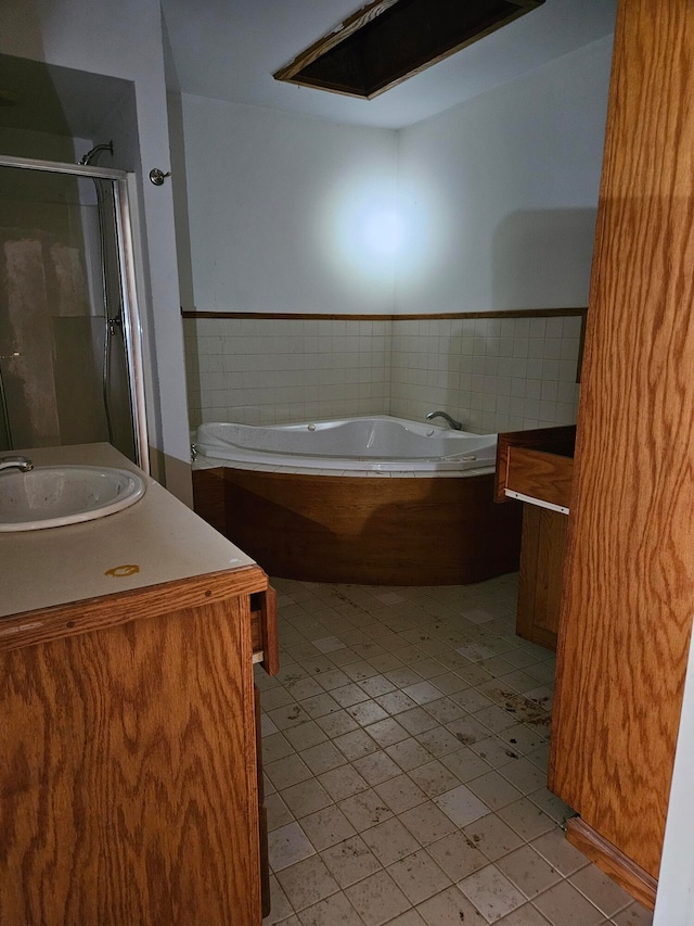 bathroom featuring tile patterned floors, plus walk in shower, and vanity