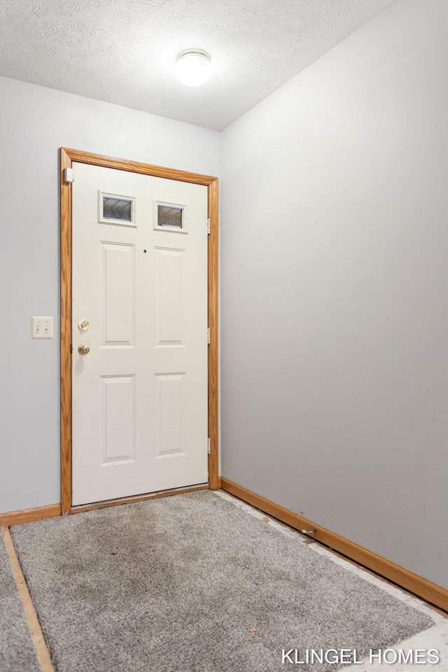 carpeted entrance foyer featuring a textured ceiling