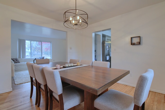 dining room featuring light wood-type flooring and a notable chandelier