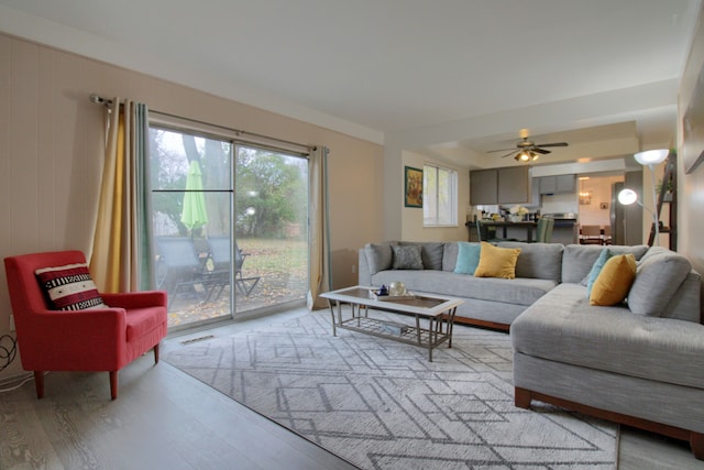 living room with light hardwood / wood-style floors and ceiling fan