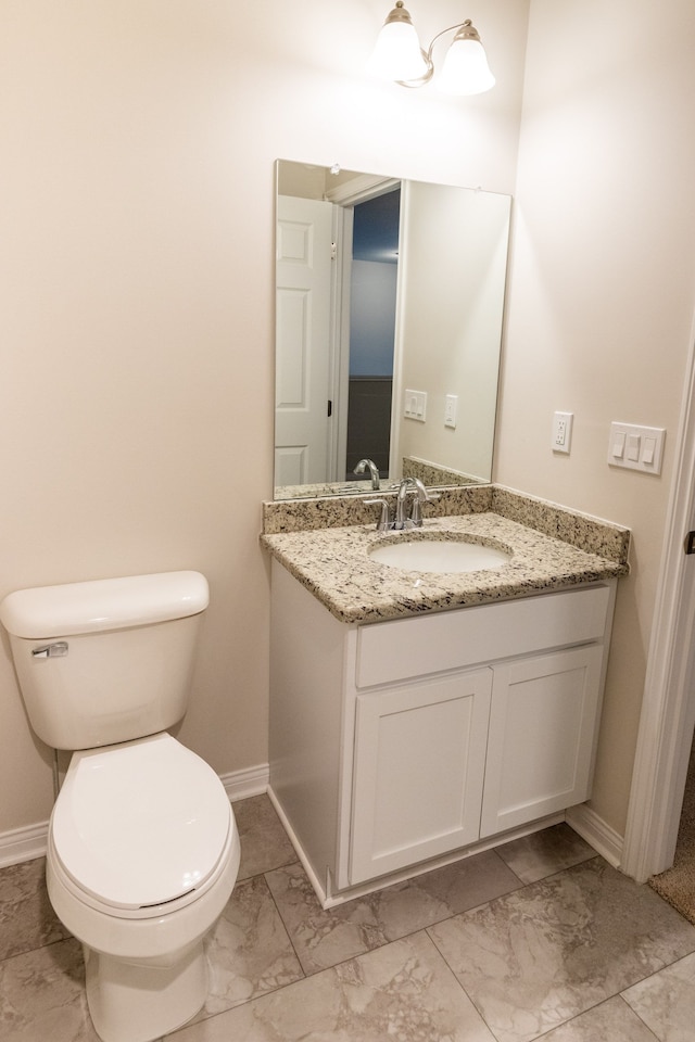 half bathroom featuring marble finish floor, baseboards, and toilet