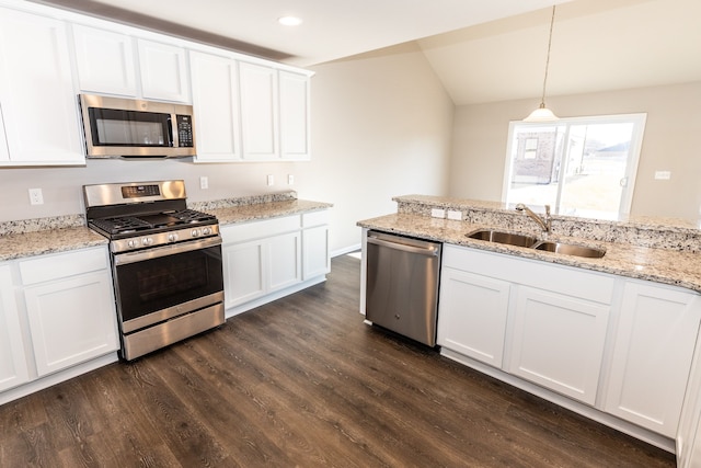 kitchen featuring dark wood-style floors, appliances with stainless steel finishes, white cabinetry, pendant lighting, and a sink