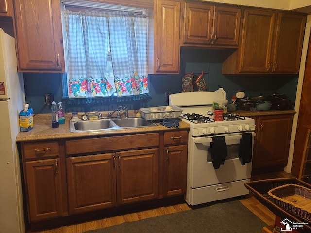 kitchen featuring sink, white appliances, and dark wood-type flooring