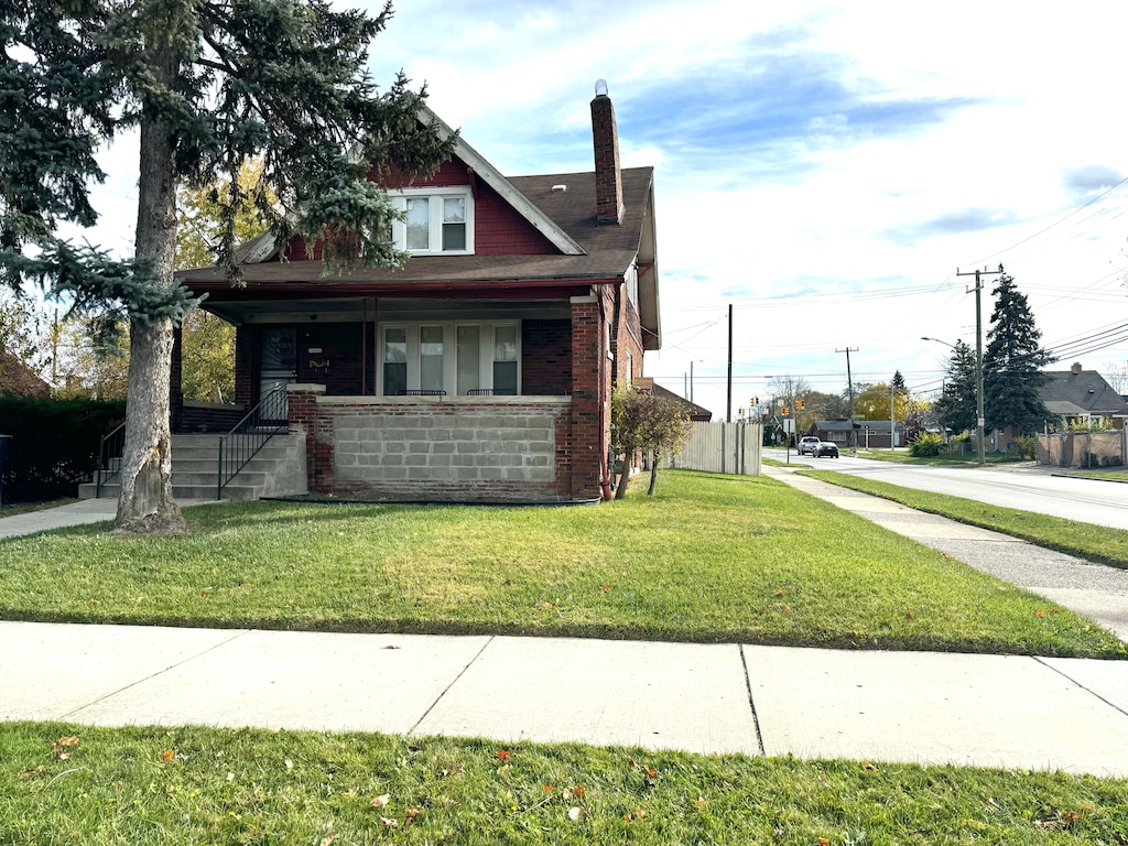 view of side of home featuring a yard and a porch