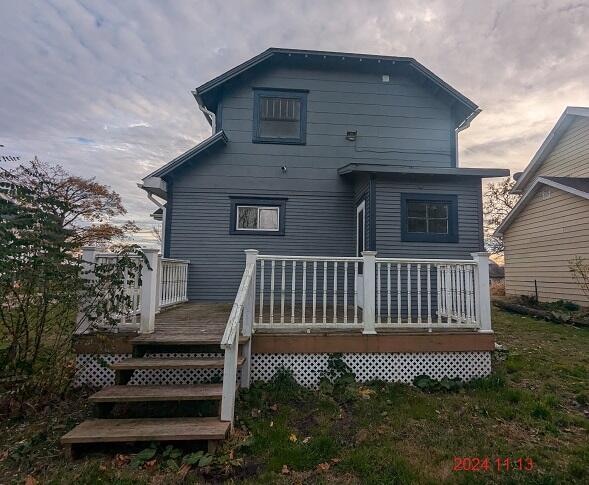 rear view of house featuring a wooden deck