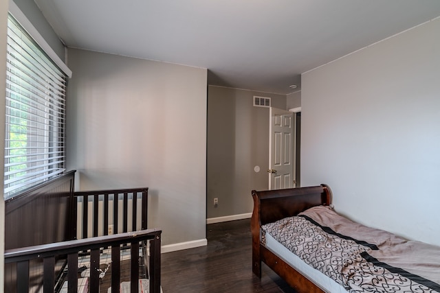 bedroom with dark hardwood / wood-style floors