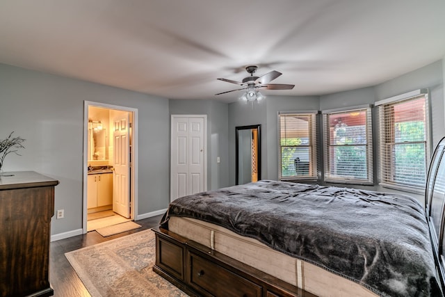 bedroom featuring dark hardwood / wood-style flooring, ensuite bath, multiple windows, and ceiling fan