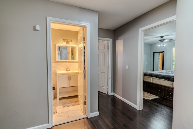 hallway featuring sink and dark wood-type flooring