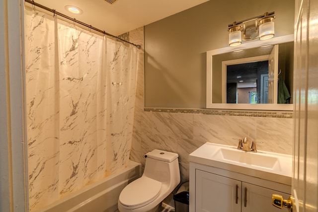 full bathroom with vanity, toilet, tile walls, and shower / tub combo