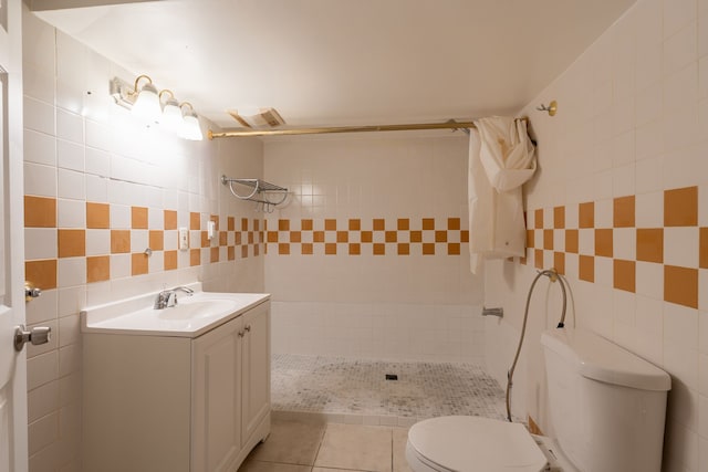 bathroom featuring a shower with shower curtain, vanity, tile walls, tile patterned flooring, and toilet