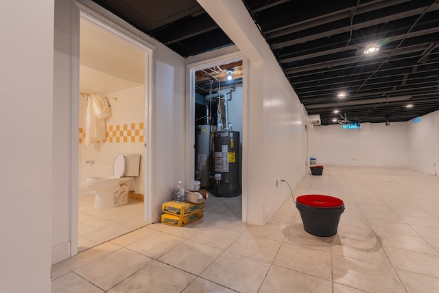 basement with light tile patterned floors and water heater