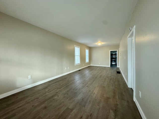 unfurnished living room with dark wood-type flooring