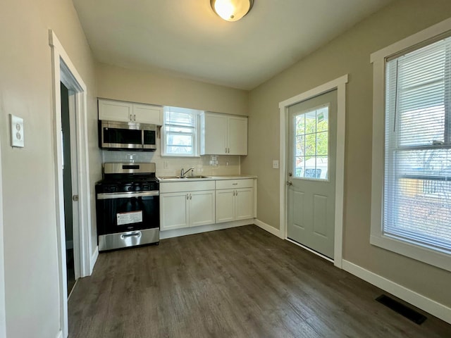 kitchen featuring a healthy amount of sunlight, white cabinets, and stainless steel appliances