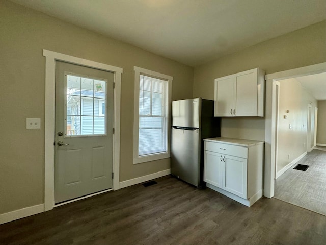 kitchen featuring white cabinets, stainless steel fridge, and dark hardwood / wood-style flooring