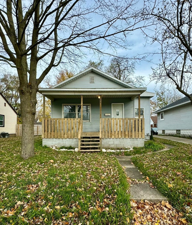 bungalow-style home featuring covered porch and a front yard