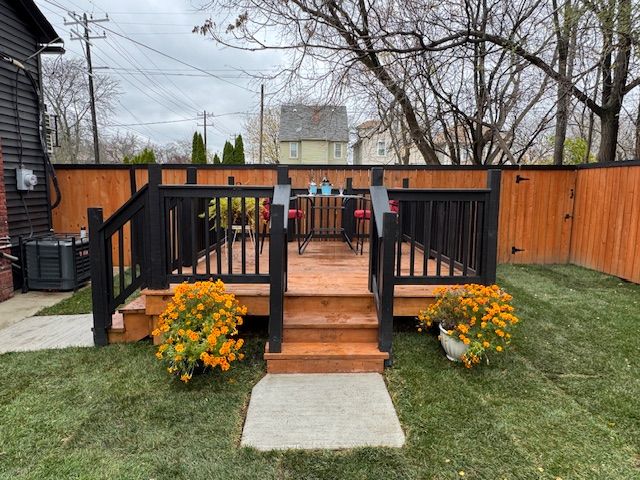 wooden terrace featuring a lawn and central AC