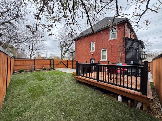 rear view of property featuring a wooden deck and a yard