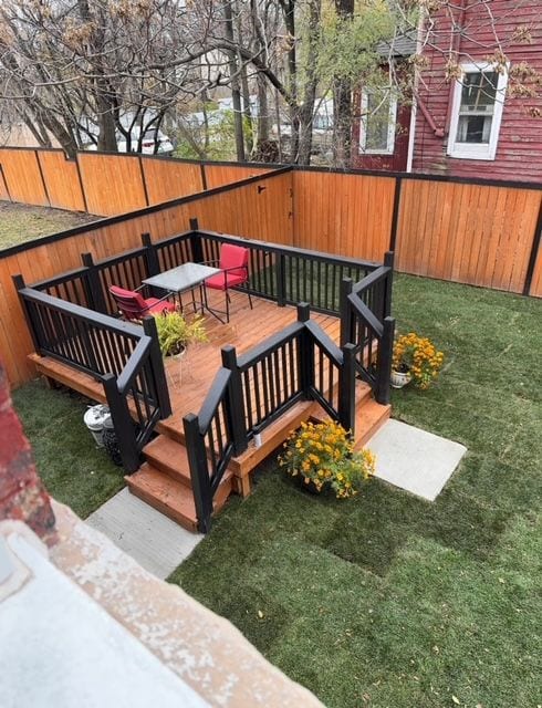 wooden terrace featuring a yard